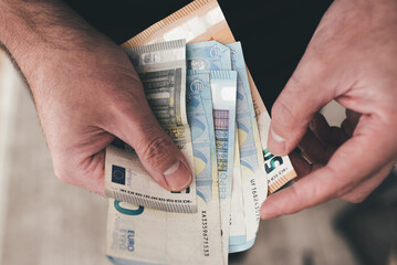 top down view of hands of man holding euro bills, counting money