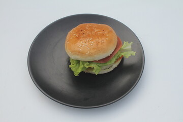 a portion of burger with meat and vegetable filling on a round ceramic plate