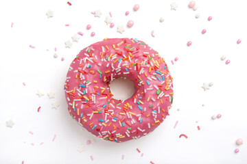 Glazed donut with pink icing with sprinkles on white background. Close-up.