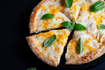 Italian pizza Margherita with cheese and basil on black concrete table top view