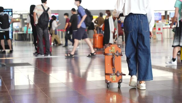 空港でキャリーバックを持って歩いている日本人の女性