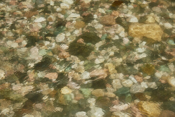 abstract blurred background. A fragment of a mountain river. Colorful stones under the water.