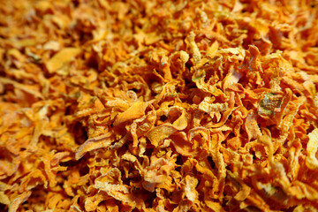 a lot of orange dried carrots close up.  side view.  dried vegetables.  dry carrot pieces