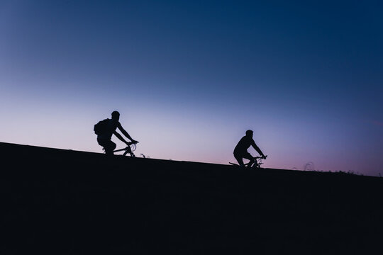 Beautiful Couple on bicycles silhouette sunset two bike ride, road trip active life style concept