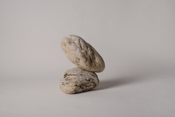 two balancing pebbles on neutral background