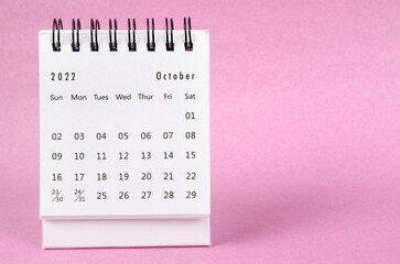 Obraz na płótnie Canvas The October 2022 desk calendar on pink color background.