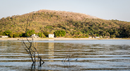 Linda paisagem, com céu dourado e limpo, e  montanha ao fundo na praia de água doce da represa da Várzea das Flores, em Contagem, Minas Gerais, Brasil.