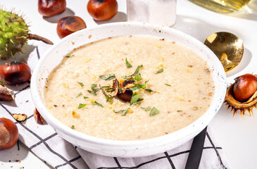 Homemade roasted chestnut soup. Autumn cream soup with chestnuts on white background