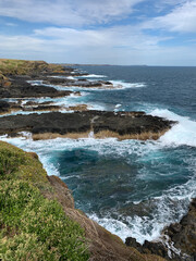 Ocean waves crashing against cliffs at Phillip Island, Australia.