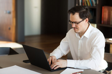 man businessman working in office or at home at table on laptop.