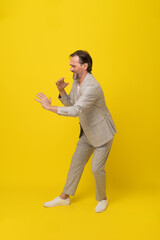 Musician middle aged business man pretend playing saxophone laughing with eyes shut isolated on...