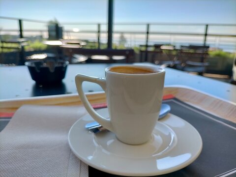 cup of coffee in a rooftop cafe, open terrace with metal tables