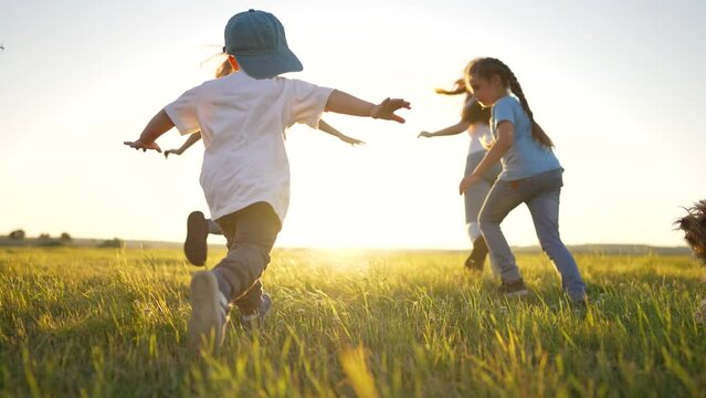 Happy family concept.Child run hand to the sides in park.Child play with dog in field on green grass.Family games of friend at sunset.Dream kid in summer in park.Family jogging in green grass with dog