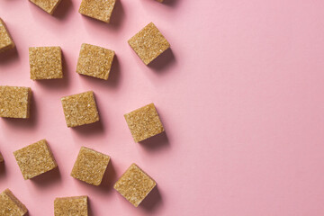 Cane sugar on a pink background. Brown refined cane sugar.	