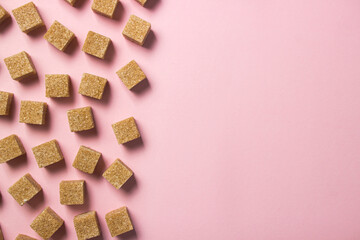 Cane sugar on a pink background. Brown refined cane sugar.	