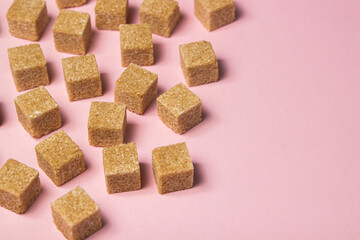 Cane sugar on a pink background. Brown refined cane sugar.	