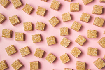 Cane sugar on a pink background. Brown refined cane sugar.	