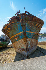 Rusty wreck boat moored at the marina of Camaret Sur Mer, Brittany, France. Text translation...