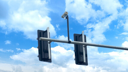 Beside view of dual panel traffic light with centralized surveillance camera. Under day time of...
