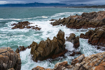 Fototapeta na wymiar The rocky coastline of Walker Bay at De Kelders near Gansbaai in the Overberg, Western Cape. South Africa