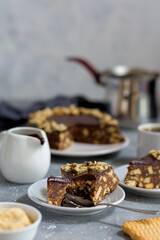 A piece of chocolate cookie cake with a broken piece of a spoon, the background of the cake is out of focus.