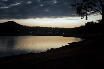 Lindo pôr do sol ao entardecer com céu azul limpo, com reflexo em lago no bairro Jardim das Oliveiras, Esmeraldas, Minas Gerais.