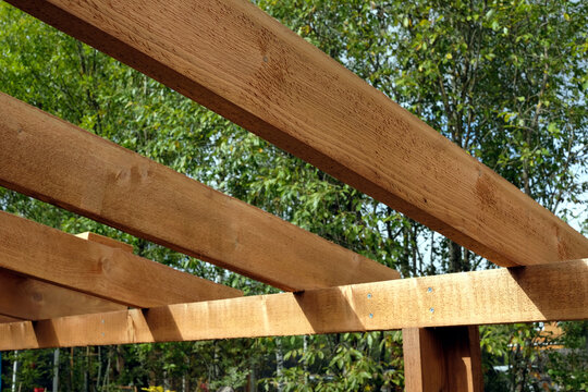 The process of building a wooden canopy from brown boards in the countryside in summer day 