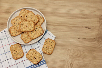 dry square diet crackers with black cumin seeds and quinoa on a decorative glass plate
