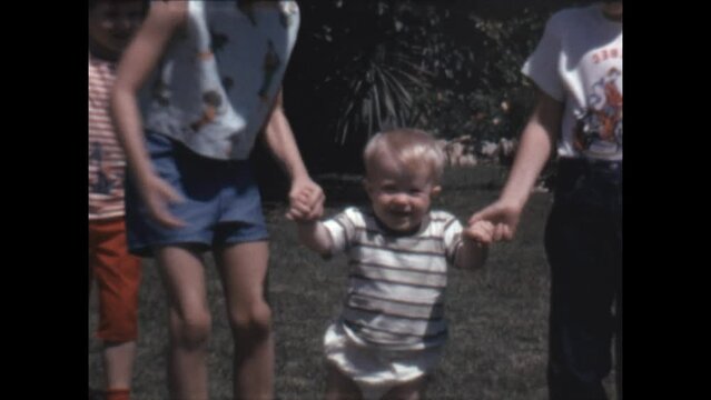 Helping Brother Walk 1964 - Siblings help their brother as he is learning to walk in Canoga Park, California in 1964. 
