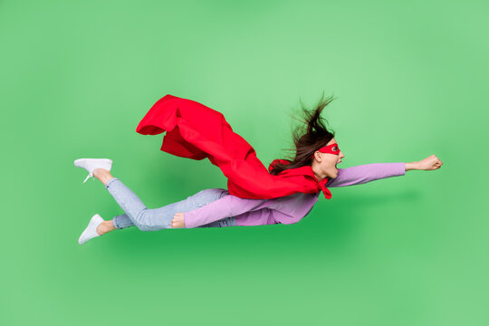 Full size photo of young sporty energetic girl crazy fist up fly fast speed superhero adventures against evil isolated on green color background