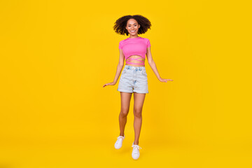 Fototapeta na wymiar Full body portrait of overjoyed carefree girl jumping have good mood isolated on yellow color background