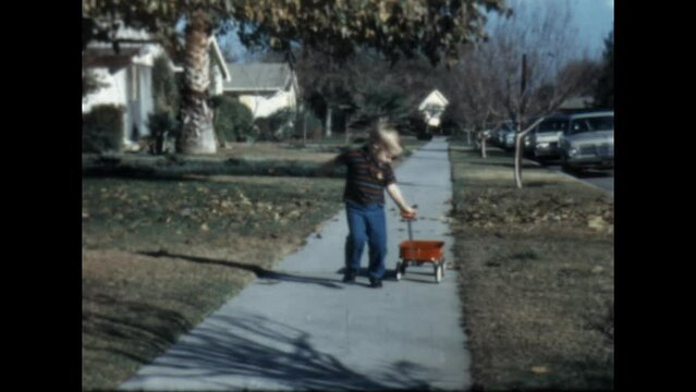 Pulling a Wagon 1967 - A boy pulls a wagon in front of his home in Canoga Park, California in 1967. 