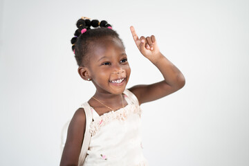 Una ragazzina sorridente in età scolare attira l'attenzione alzando il dito indice e indicando un posto per una scritta per pubblicità e sconti. Isolato su sfondo bianco
