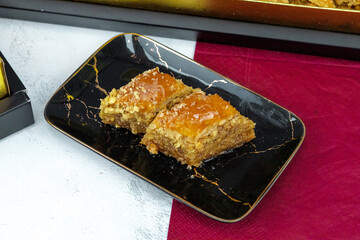 Portion of baklava with walnuts on a marble plate