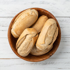 Whole grain french bread, salt bread or pistolet in a bowl over wooden table