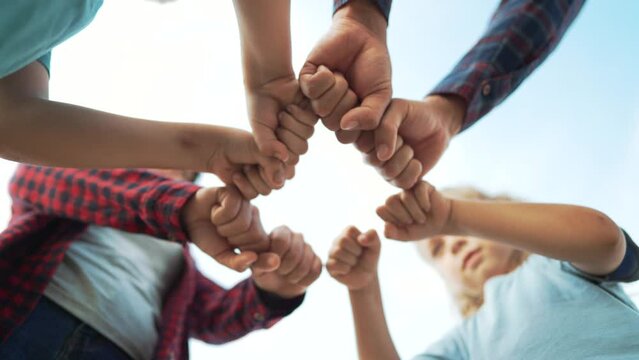 Team of people together in nature. Unity and commonwealth family happiness. Hands in the form of punches are a symbol of teamwork. Family friendship together in nature. Business cooperation concept.