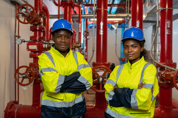 Portrait of engineer or technician maintenance, checking, or test system springer prevent fire. Group of African American contractor checking fire sprinkler system, pipe assembly, red fire pipe - obrazy, fototapety, plakaty