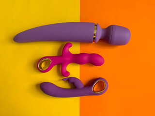 Three vibrators on orange background. Sex toys for orgasm. Useful for sex shop, adult shop