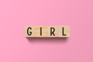 Girl on wooden cubes. Light pink background