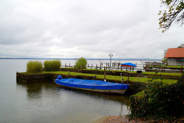 boats resting on the water on a rainy overcast day on island Fraueninsel on lake Chiemsee in Bavaria, Germany