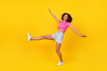 Fototapeta na wymiar Full length photo of satisfied cheerful person have good mood raise leg isolated on yellow color background