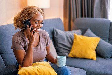 Woman speaking on the phone while relaxing at home