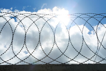 barbed wire fence on sky background, sky behind wired fence