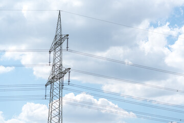 Electricity pylon for over land power transmission of high voltage in front of blue sky