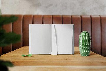 Clean minimal Inner book 4x6 mockup on top wooden table with plant