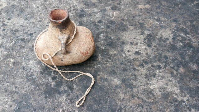 Botella r&uacute;stica de arcilla con cuerda en el asa