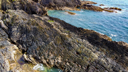 Calm sea surface and rocky shore. Coastal landscape, top view. Aerial photo.