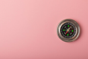Classic round compass on a pink texture background. The concept of tourism with a compass. travel with a compass. Vacation or outdoor activities with a compass.Place for text. Copy space