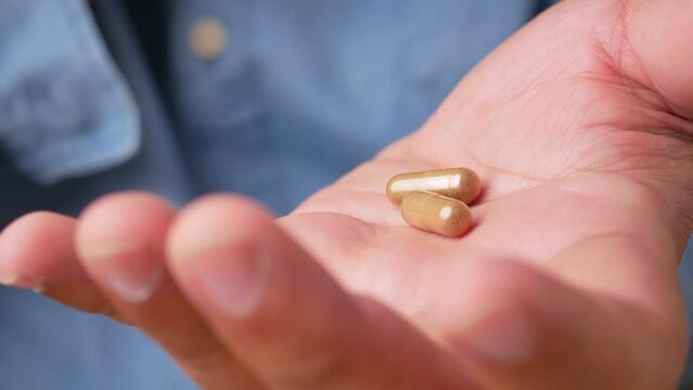 Men taking medicine capsules for taking and treating health care, close up