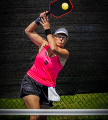 Female pickleball player about to smash the ball for a winner